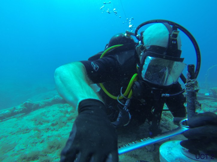 A steelworker works on an underwater cable.